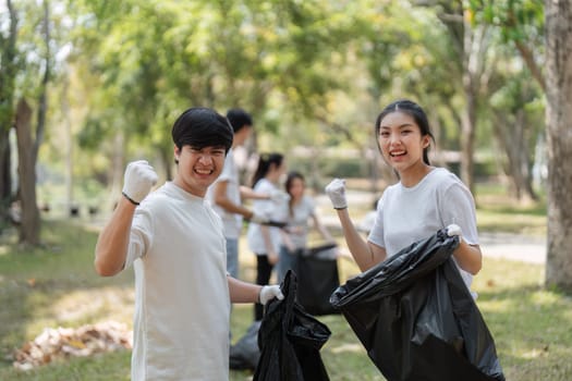 Two young volunteers celebrating their efforts with a fist pump, demonstrating enthusiasm for their community cleanup initiative.
