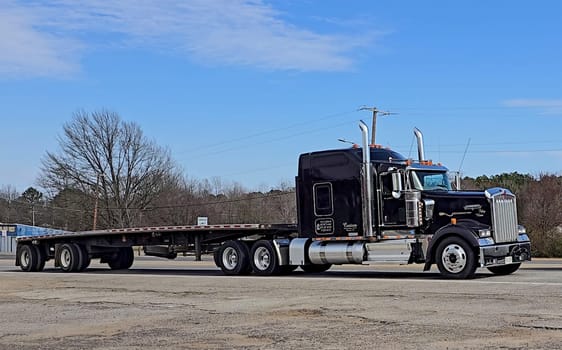Freight liner Semi-Truck Driving on Open Highway in a Rural Area, CDL Truck America, semi truck and trailer travels along an open road under a blue sky in a rustic rural setting, showcasing commercial transportation, logistics efficiency, and professional trucking