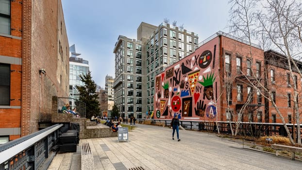 Manhattan, New York, USA - February 16, 2024: View of the Hight Line with its typical buildings seen from above as people visit on a gray winter day