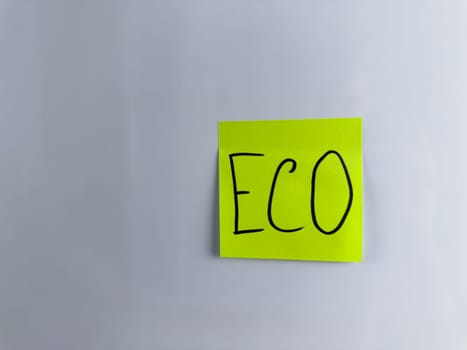 Eco concept with simple design. Photo for project about environment care. Word Eco written on sticky note on white background. Attracting attention to problems of pollution of nature and ecology