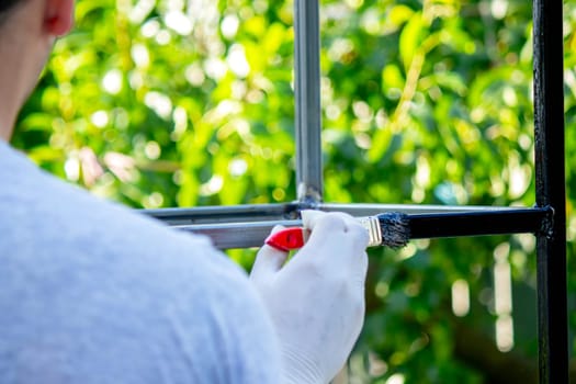 close up of painting metal with brush in garden