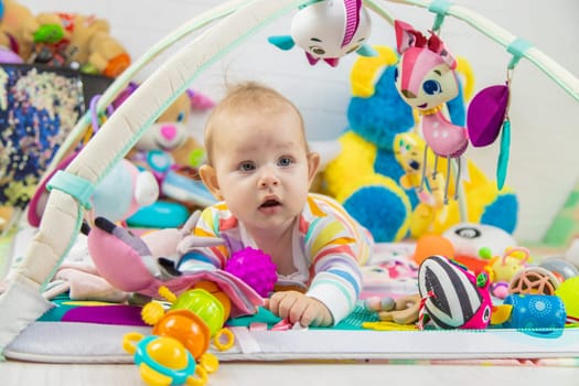 Baby playing on a toy mat. Child with an educational toy. Early development.