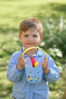 Boy collects the eggs in a basket Easter