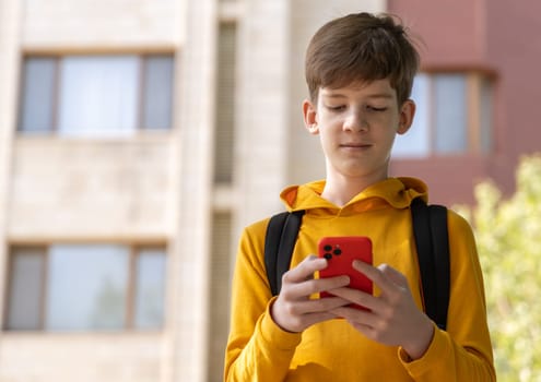Teenage boy with a smartphone smiles while looking at the screen. Highlights endless opportunities for learning, entertainment, and communication through digital devices