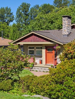 Perfect neighbourhood. Entrance door steps and paved pathway in front of residential house main entrance with decorative flowers.