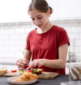 Young Girl Makes Breakfast In The Kitchen At Home
