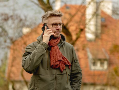Young Attractive Man On A Street Has A Smartphone Call, Portrait In Glasses