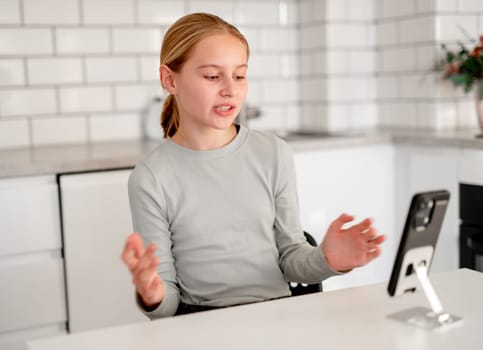 Cute Little Girl Talks With Friends Via Video Call Using A Smartphone At Home