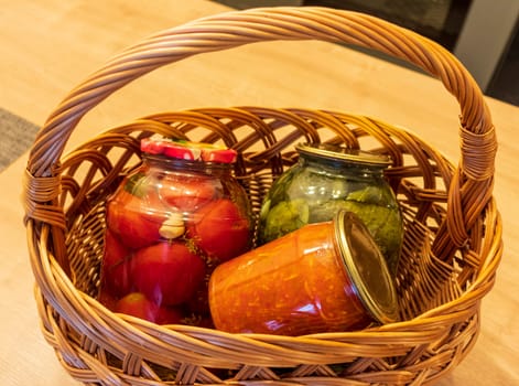 Jars with different types of pickles and preserves in a wicker basket