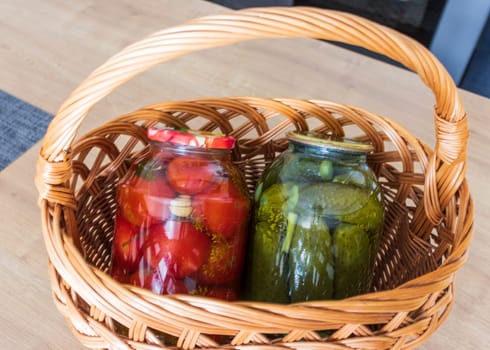Jars with different types of pickles and preserves in a wicker basket