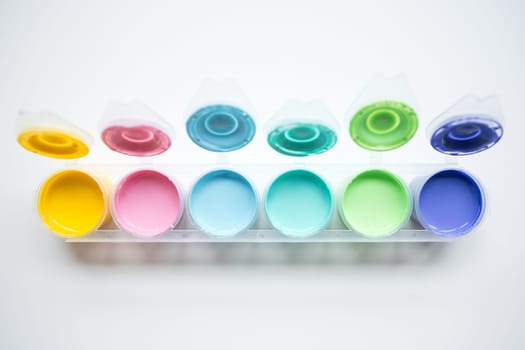 Colorful paint set with open lids displaying vibrant hues.