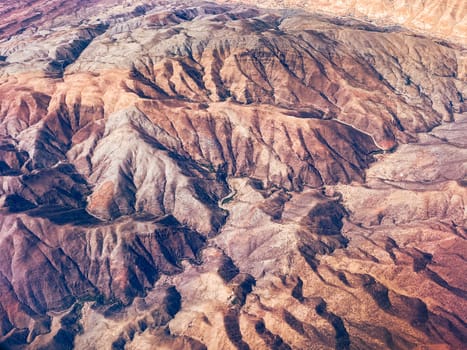 Aerial view of high desert mountains. Mountain landscape. Beauty in nature. Inaccessible mountain peaks. Harsh climate. Looking at the Earth from an airplane window. Aerial view of the land. Africa land