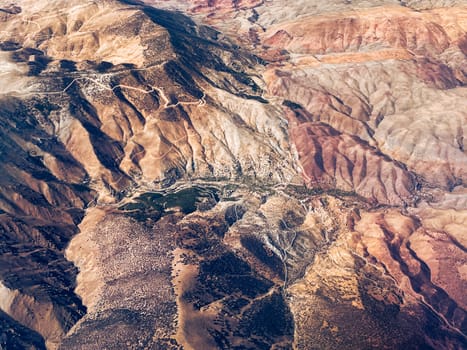 Aerial view of high desert mountains. Mountain landscape. Beauty in nature. Inaccessible mountain peaks. Harsh climate. Looking at the Earth from an airplane window. Aerial view of the land. Africa land