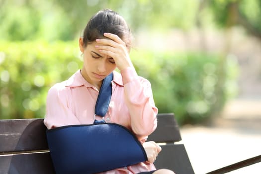 Worried convalescent woman sitting on a bench complaining in a park