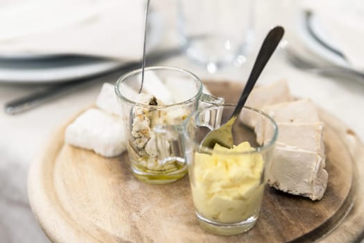 Wooden plate with cheese and sauces. Antipasti. Party. Events.