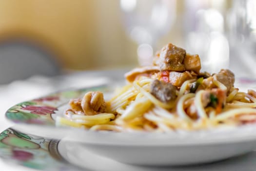 Selective focus on Italian Traditional Pasta "Spaghetti with fish"", spaghetti with fish and tomato sauce and vegetable."