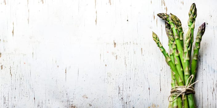 Top view of fresh green asparagus vegetable on vintage wood table. Healthy food background. Organic green vegan grocery from above. Restaurant menu design layout.