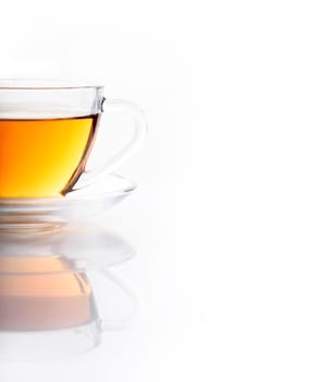 Herbal green tea with in transparent teacup isolated on white background with reflection. Traditional english hot beverage in glass cup. Organic healthy herbs for alternative medicine.
