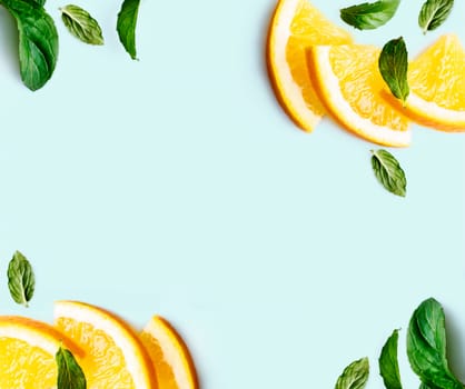 Citrus slices and mint herbs frame on retro mint pastel background with copyspace from above. Top view of lemon and orange refreshment. Summer fruit smoothie minimal banner design. Flat lay.
