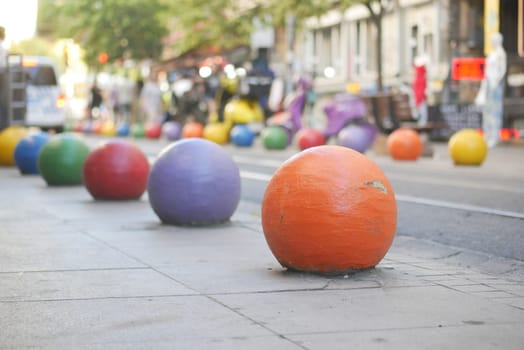 Brightly painted spheres decorate the pavement of a city street.