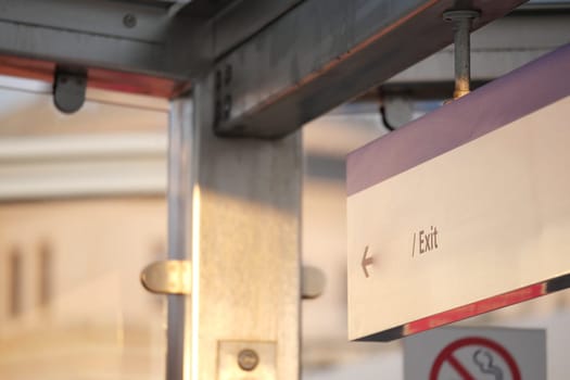 Sign indicates exit direction at a busy urban transit station.