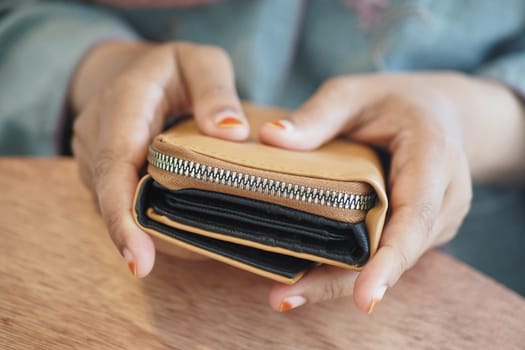 A person is holding a closed leather wallet with a sleek design.