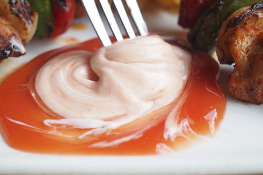Creamy sauce blends with ketchup beside grilled vegetable skewers.