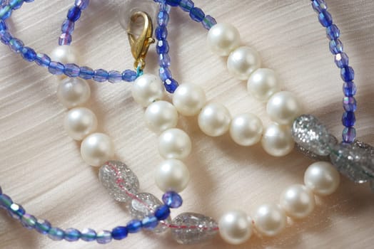 Various necklaces featuring pearls and colorful beads are displayed elegantly.