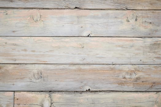 Textured wooden planks display a soft gray color with rustic charm.