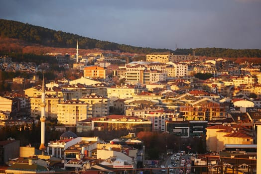 Buildings reflect warm light during sunset in a bustling city.