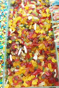 A vibrant mix of gummy candies fills a display case at a shop.