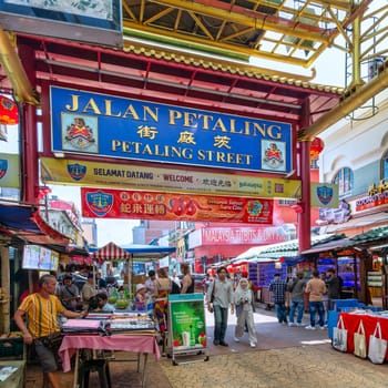 Kuala Lumpur, Malaysia - Feb. 16, 2025: .Visitors explore the lively stalls of Petaling Street, a bustling market. Colorful signs, street vendors, and a diverse crowd create a vibrant shopping scene
