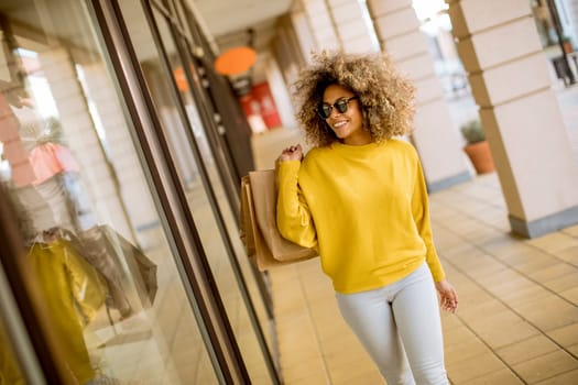 Pretty young black woman with curly hair in shopping