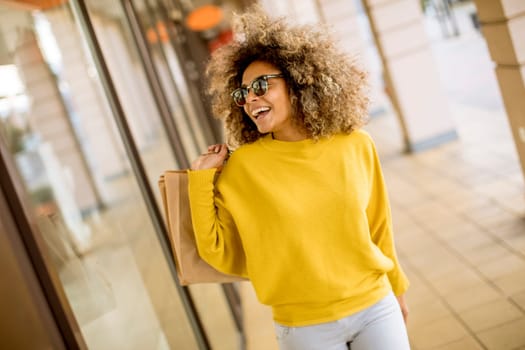 Pretty young black woman with curly hair in shopping