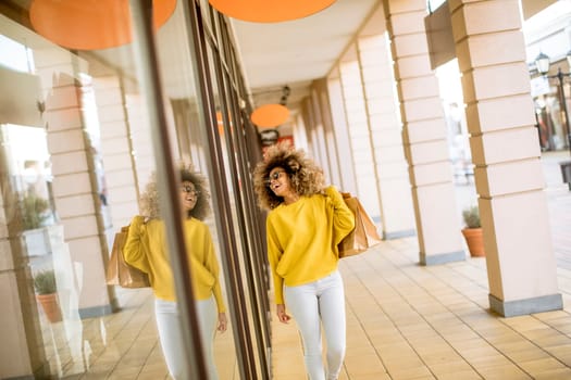 Pretty young black woman with curly hair in shopping