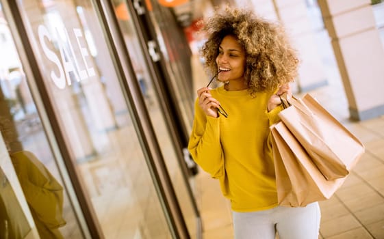 Pretty young black woman with curly hair in shopping