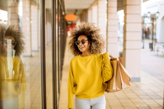 Pretty young black woman with curly hair in shopping