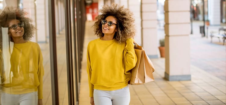 Pretty young black woman with curly hair in shopping