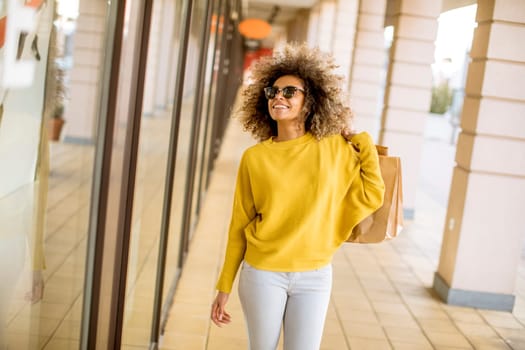 Pretty young black woman with curly hair in shopping