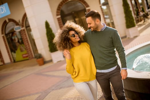 Lovely young multiethnic couple walking on the street