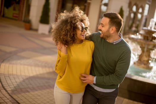Lovely young multiethnic couple walking on the street