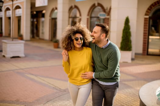 Lovely young multiethnic couple walking on the street