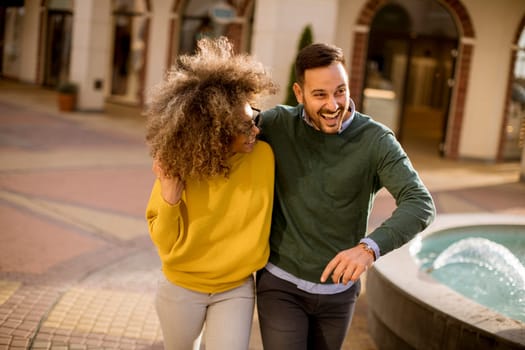 Lovely young multiethnic couple walking on the street