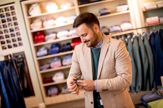 Handsome young man buying suit in the store