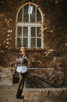Pretty young woman standing outside at sunny autumn day