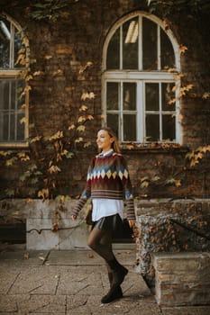 Pretty young woman walking in the autumn park on a sunny day