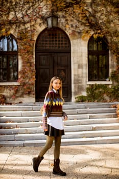 Pretty young woman walking in the autumn park on a sunny day