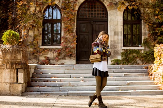 Pretty young woman walking in the autumn park on a sunny day