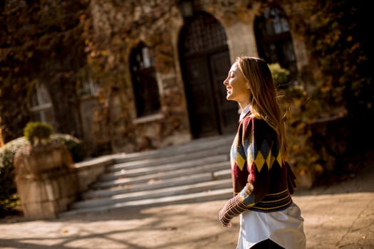 Pretty young woman walking in the autumn park on a sunny day