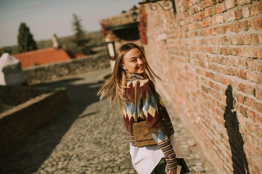 Pretty young woman walking in the autumn park on a sunny day